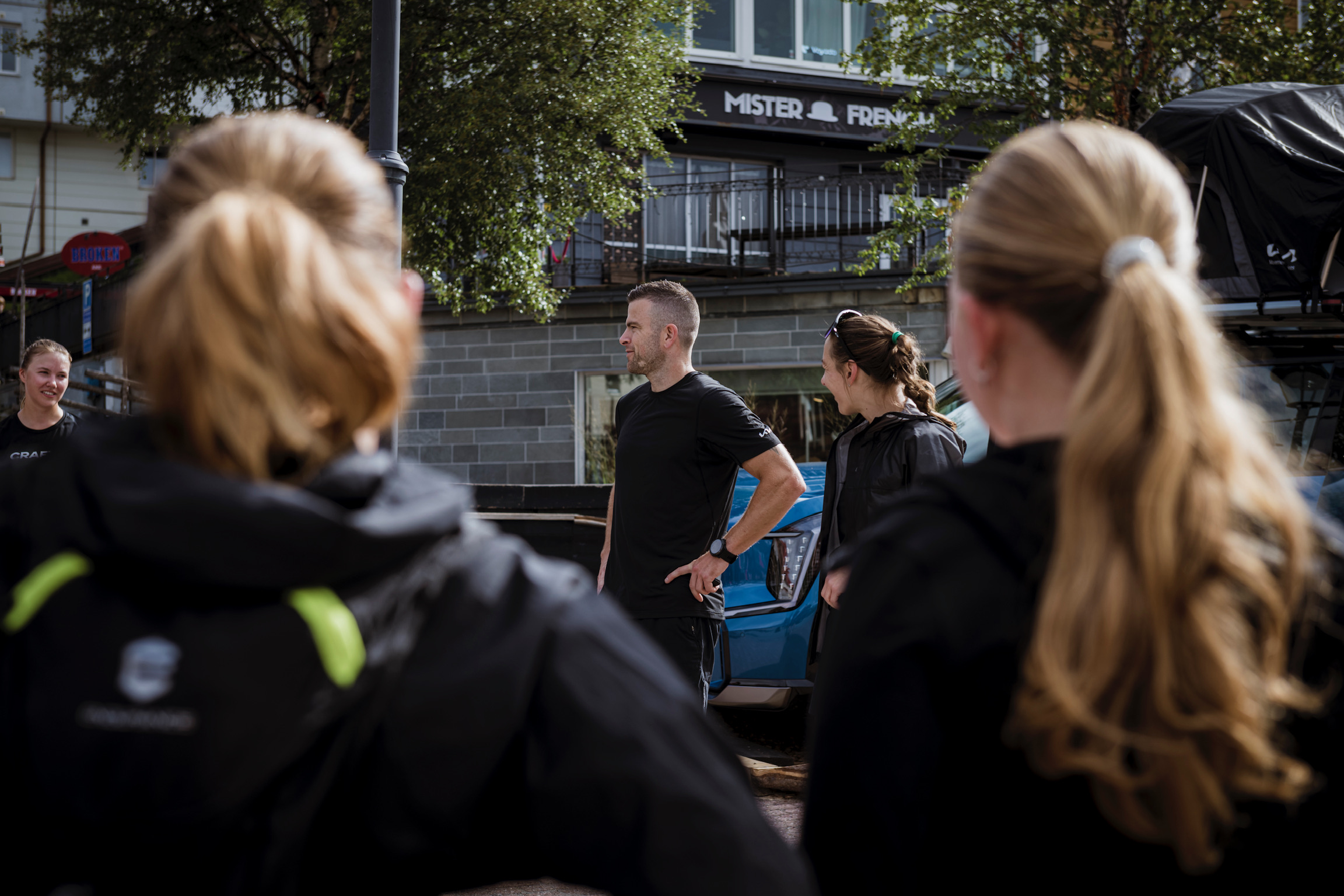 Patrik Widell står i samtal med en grupp människor under en utomhusaktivering.